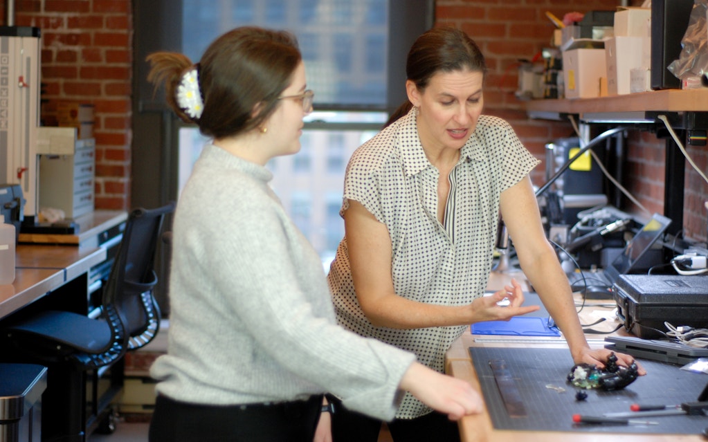 Melanie and engineer inspecting a device