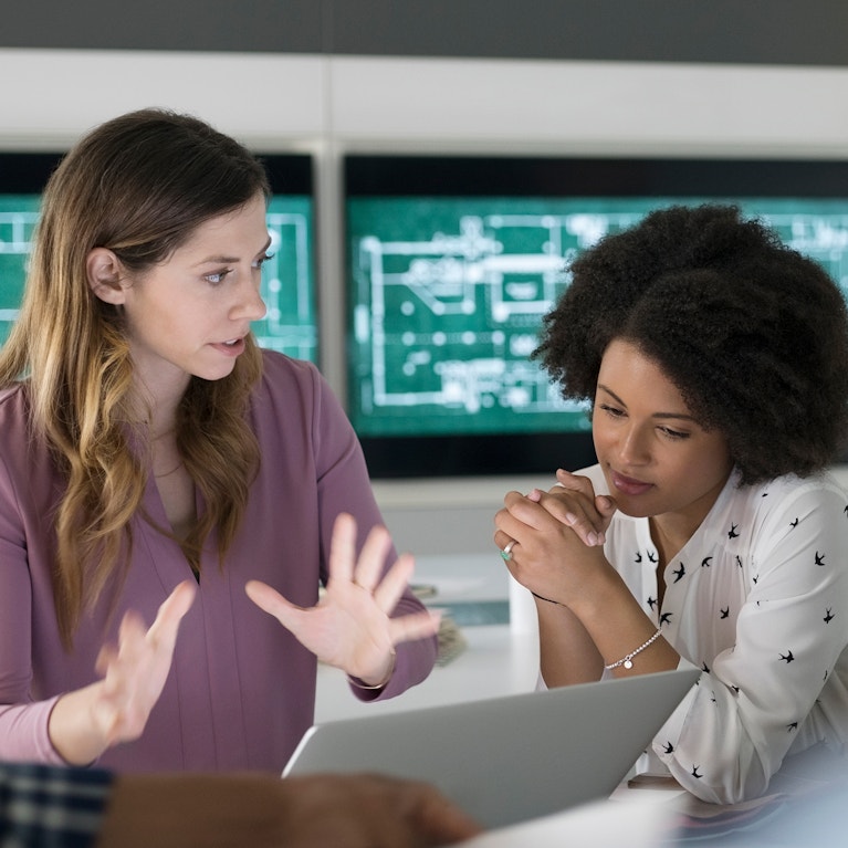 Female architects planning at laptop in conference room meeting