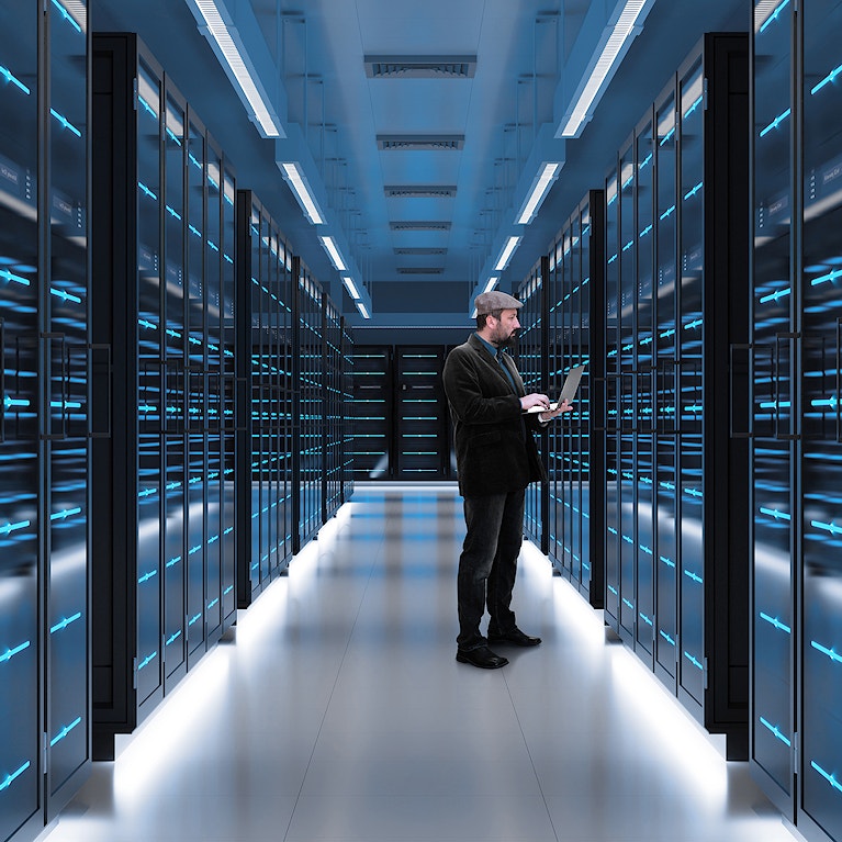 Man working on laptop in server room