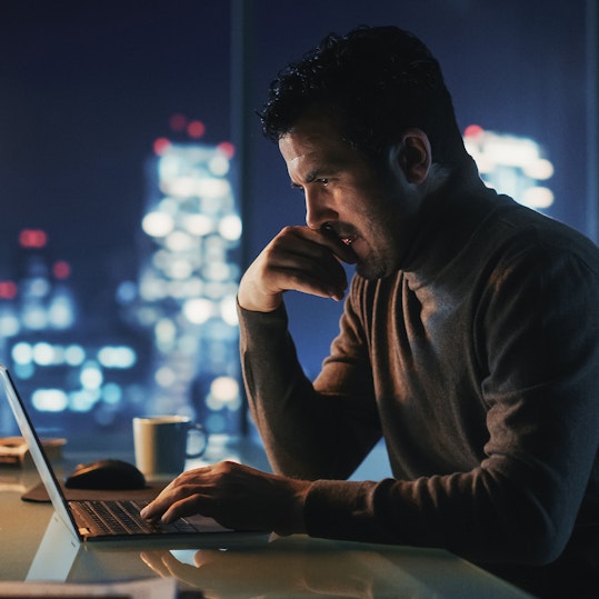 A person working on a laptop at nighttime