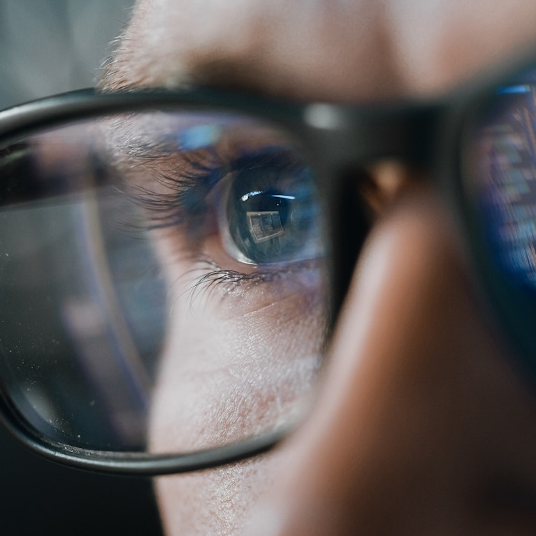 Close-up Portrait of Software Engineer Working on Computer, Line of Code Reflecting in Glasses. Developer Working on Innovative e-Commerce Application using Machine Learning, AI Algorithm, Big Data.