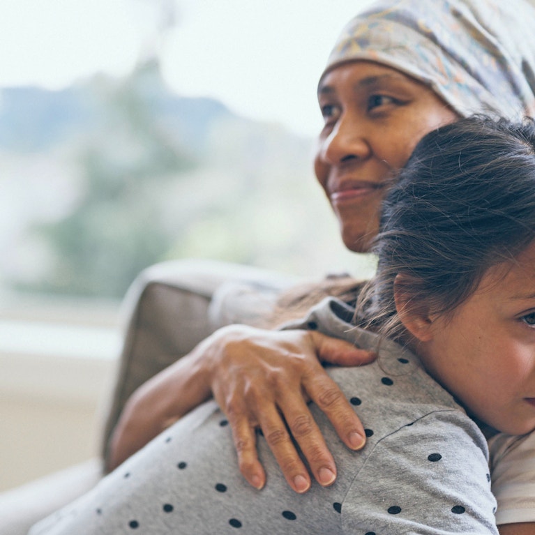 Woman wearing headwrap hugging child