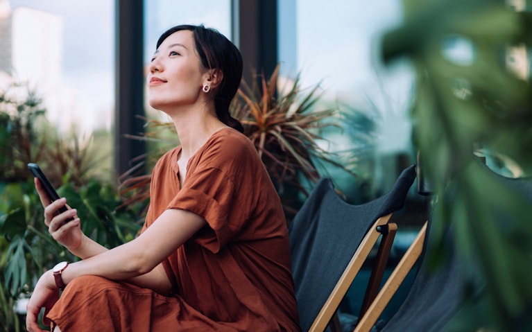 A woman inside an indoor garden sitting down