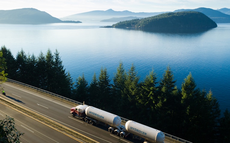 Hydrogen tanker truck driving on lakeside highway