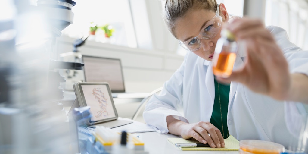 Scientist examining liquid in jar