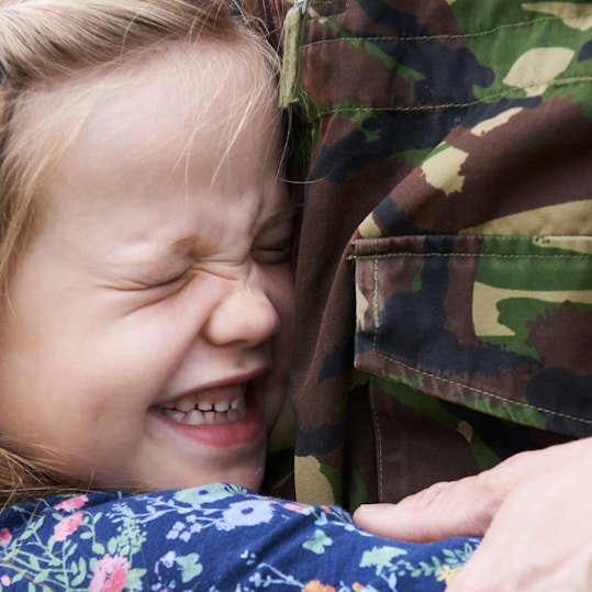 Young girl hugging a member of the armed forces