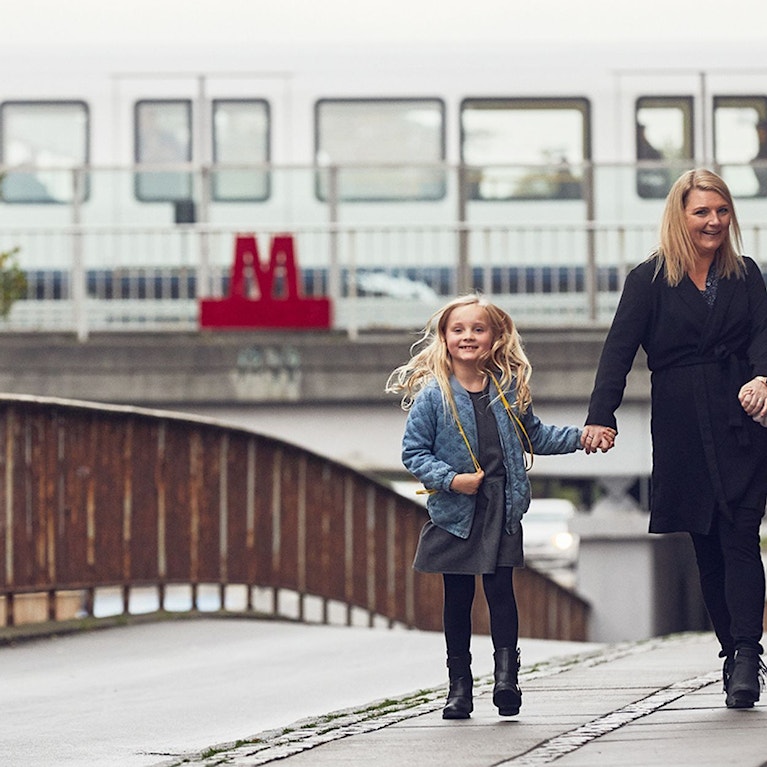 A lady with two kids in front of The Copenhagen Metro.