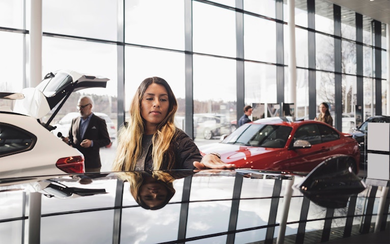 Woman assessing a vehicle in car dealership