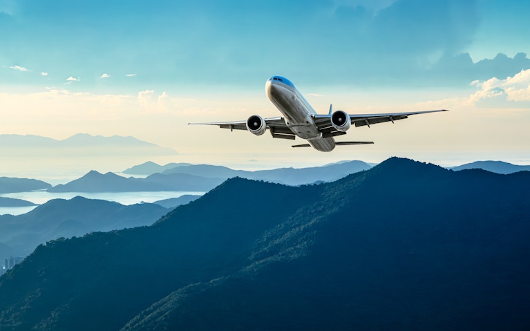 Plane takes off over green hillside