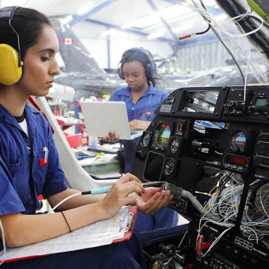 Young female engineers working with helicopters