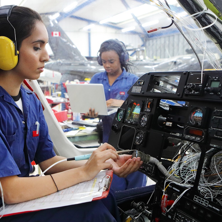 Young female engineers working with helicopters