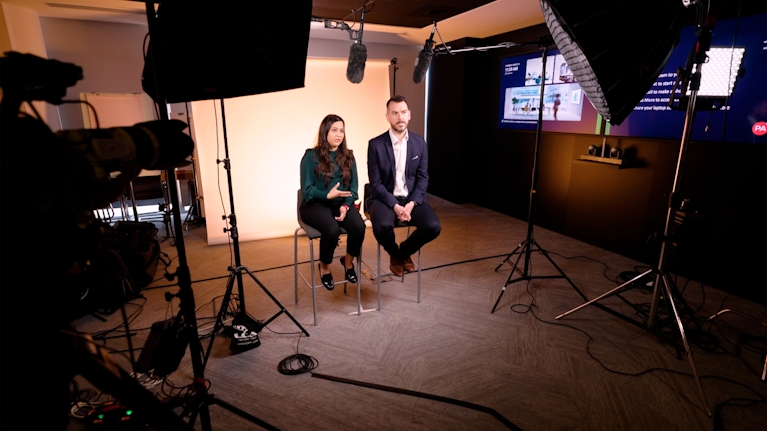 Two people sitting in a video recording studio