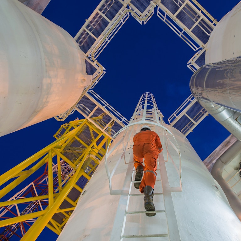 Worker climbing gas pipe ladder