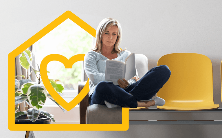 Woman seated on row of chairs reading document