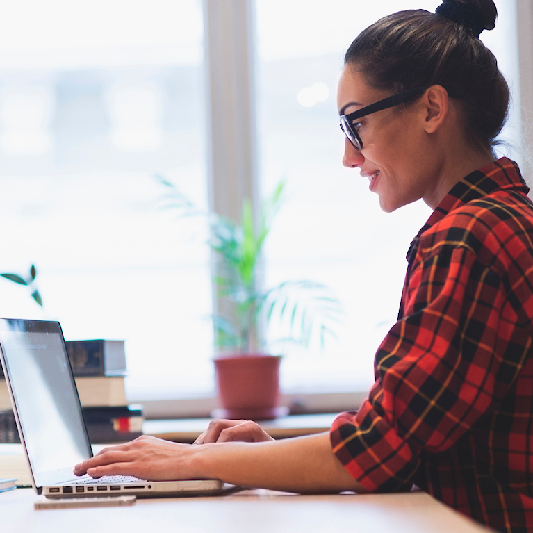 Young hipster girl working on laptop