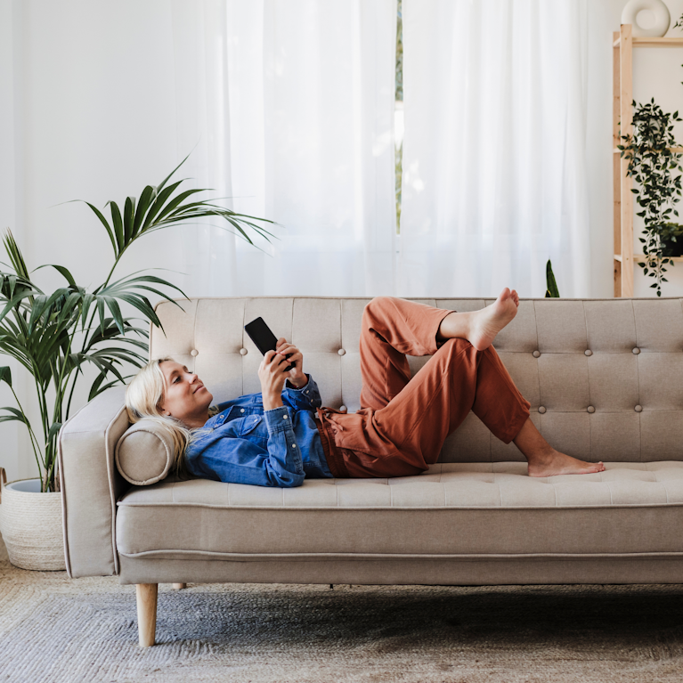 Woman using device on sofa