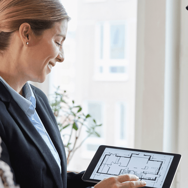 Real estate agent showing property plan to homeowners